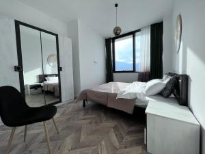 第比利斯Apartment in AXIS TOWERS, Tbilisi business center的一间卧室配有一张床、一把椅子和镜子