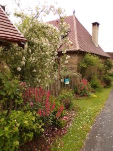 Meuzacla maison de Royer的一座带鲜花和围栏的花园的房子