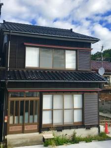 佐渡市Lu Blue Sado SAWANE - Vacation STAY 12885的白色窗户和黑色屋顶的房子