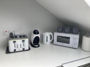 CastlepollardLir Lodge的厨房柜台配有微波炉和电器。