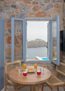 Livadi AstypalaiasNisides Suites的窗前有盘子食物的桌子