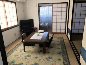 熊本Family House - Vacation STAY 53010v的客厅配有木桌和地毯。