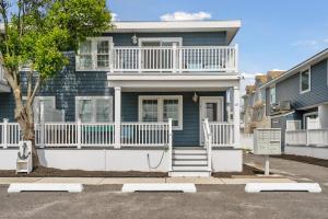 布里根泰恩Beach Block Parking Modern Decor Porch的蓝色的房子,设有白色门廊和楼梯