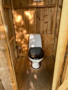 RabjergTreehouse B&B的木质结构中带黑色座椅的卫生间