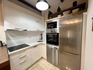 维拉加尔西亚·德·阿劳萨Preciosa casa marinera en Carril的厨房配有白色橱柜和不锈钢冰箱