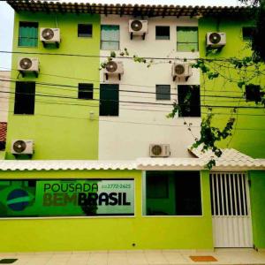 马卡埃Pousada Bem Brasil的一座绿色的白色建筑,上面有扬声器
