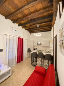 维泰博Casa medievale Il Rifugio di Olimpia的一间带红色沙发的客厅和一间厨房