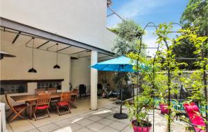 蒙布舍叙尔雅布龙Amazing Home In Villeneuve De Berg With Kitchen的庭院配有木桌和蓝伞。