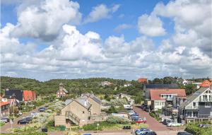 滨海贝亨De Tuimelaar的街道上拥有房屋和汽车的小城镇