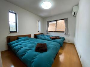 轻井泽Angel Resort Karuizawa的带2扇窗户的客房内的2张蓝色床