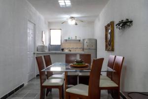 坎昆Blanca的厨房配有桌椅和冰箱。