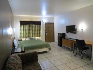 Laguna VistaExecutive Inn Laguna Vista的配有一张床和一张书桌的酒店客房