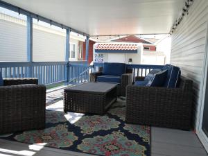 伊莎贝尔港LIV Resort: Clam Circle with Private Jacuzzi (Pet Friendly)的阳台的庭院配有藤椅和桌子