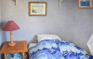 科尔莫登Nice Home In Kolmrden With Kitchenette的一间卧室配有一张床和一张带台灯的桌子
