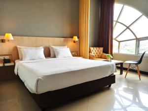 巨港Rio City Hotel的一间卧室设有一张大床和一个大窗户