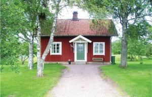 LundsbrunnAmazing Home In Lundsbrunn With 3 Bedrooms的红色的房子,有红色的屋顶和通往房子的通道