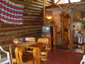 San RoqueCabañas El Milagro的小屋内带桌子和电视的用餐室