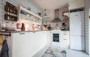 比耶克维克Nice Home In Bjerkvik With Wifi的厨房配有白色橱柜和冰箱。
