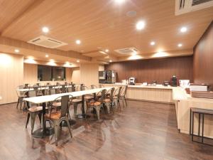 横滨HOTEL LiVEMAX Shinyokohama的一间会议室,配有长桌子和椅子