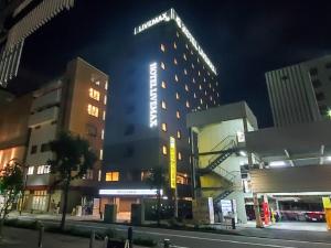横滨HOTEL LiVEMAX Shinyokohama的一座晚上有 ⁇ 虹灯标志的建筑