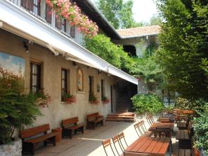 Orsenigo卡西纳扎农家乐的庭院设有木长椅和桌子,种有鲜花