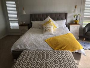奥兰治Armara Views的一间卧室配有一张带黄色毯子和枕头的床。