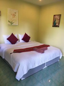 邦涛海滩Airee Mini House的卧室配有带红色枕头的大型白色床