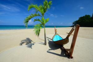奈通海滩Andaman White Beach Resort - SHA Plus的海滩上的吊床和棕榈树