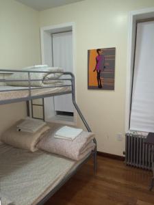 纽约Chrystie Street Apartments的客房设有两张双层床,墙上挂有绘画作品