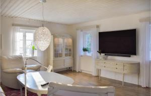 斯塔德Stunning Home In Ystad With Sauna, 3 Bedrooms And Wifi的客厅配有平面电视和桌子。