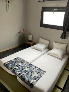 Saint-Cyr-sur-le-RhôneLe GENKI japonais 4 étoiles的两张睡床彼此相邻,位于一个房间里