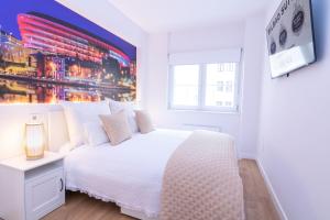 毕尔巴鄂Bilbao Henao Park de Bilbao Suites, en pleno centro con garaje directo的白色的卧室设有白色的床和窗户。