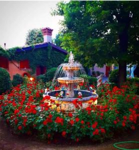 PassiranoCascina CORTEPRIMAVERA, B&B del Baliot的花园中一个喷泉,开满红花
