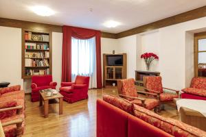 费拉迪普利米罗丽城阿尔贝格酒店的客厅配有红色家具和电视