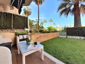 多列毛利诺斯COSTA LAGO BEACH的一个带桌子的庭院和一个种有棕榈树的草坪
