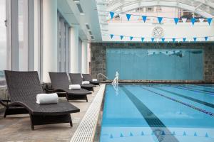 温哥华温哥华奥贝尔杰酒店的一个带椅子的游泳池,水中有人