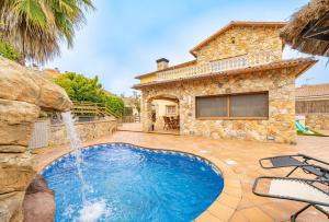 布拉内斯HomeHolidaysRentals Romeo - Costa Brava的一座房子前面带瀑布的游泳池