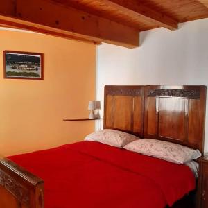 CesaraCasa Marconi Casa Vacanze的一间卧室配有一张红色的床和木制床头板