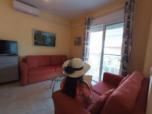 帕拉迪索Gianna's House的坐在客厅沙发上戴帽子的女人