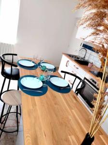 奥朗日L'Antique SPA: jacuzzi sous patio的一张木桌,配有椅子和盘子,酒杯