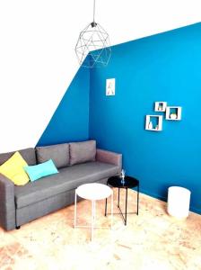 奥朗日L'Antique SPA: jacuzzi sous patio的带沙发和蓝色墙壁的客厅