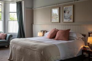 耶尔弗顿Burrator Inn的一间卧室配有带枕头的床和2个窗户。