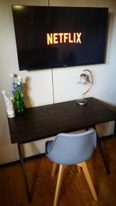 开普敦Teas & Seas Self Catering Cottage的一张桌子、椅子和墙上的电视
