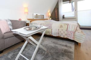 普雷罗Am Waldesrand的客厅配有一张小白桌子和一张床
