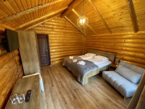 比卡兹Complex Adora的小木屋内一间卧室,配有一张床和一张沙发