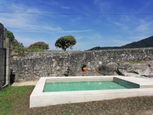 维拉·普拉亚·德·安科拉Casa do Murungal的石头墙前的游泳池