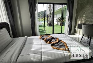 卡塔海滩Kata Hillside Hotel的卧室内的一张床铺,设有大窗户