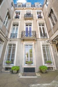 第戎Le Saint Michel的前方有窗户和盆栽植物的建筑