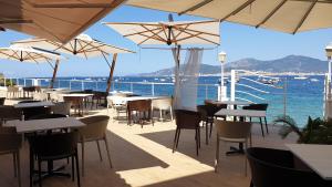波尔蒂乔Hôtel U Paradisu的一间设有桌子和遮阳伞的餐厅,享有海景