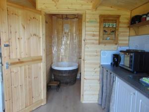 巴特尔Secret & Secluded Sedlescombe的小木屋内的厨房设有大浴缸